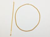 a gold necklace and a gold chain on a white background