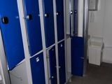 Plusieurs casiers bleus sont alignés les uns à côté des autres dans une salle de bains.