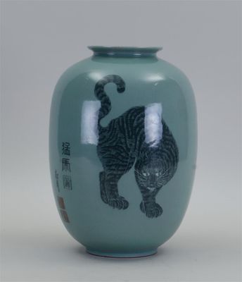 un vase vert orné d'une image de chat