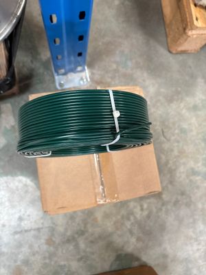 un rouleau de fil vert posé sur une boîte en carton