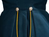 an image of a woman wearing a blue dress with gold buttons