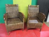 pair of wicker chairs with arms and legs on a red surface