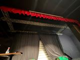 une scène avec un rideau rouge et une chaise verte