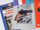 several books on a table with a gun on top of them