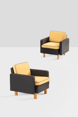 two black and yellow chairs with yellow cushions on a white surface