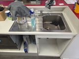a bird that is standing on a sink in the kitchen