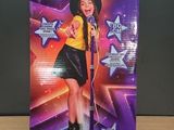 La boîte de la poupée Star Academy est posée sur la table.