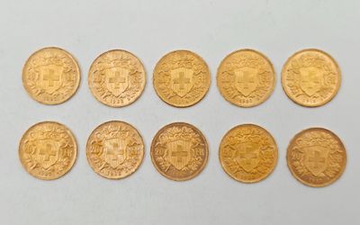 un gros plan sur plusieurs pièces d'or posées sur une surface blanche