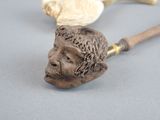 a statue of a man with a beard and a pipe on a table