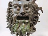 a statue of a man with a green beard and horns on it