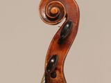 a close up of the back of a violin with a fiddle in the foreground
