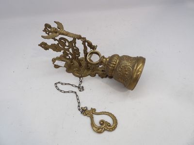 une vieille cloche en laiton à laquelle est attachée une chaîne