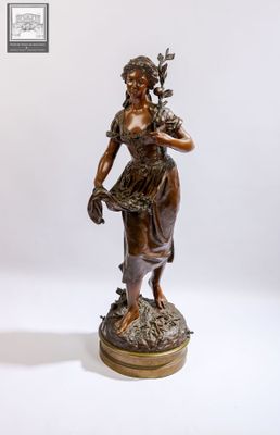 statue en bronze représentant une femme tenant un panier de fleurs, posée sur un socle