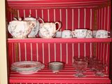 a red cabinet with dishes and cups on it