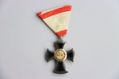 une médaille ornée d'une croix sur un fond blanc