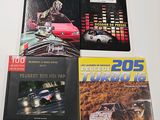 three books on a white table with a red car in the background
