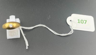 a gold and white object with a tag attached to it