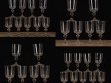 many wine glasses sitting on a wooden table