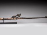 a bronze figurine of a bird on a sword on a stand