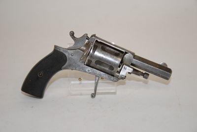 an old revolver with a wooden handle on a white surface