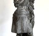 une statue représentant une femme tenant un éventail, posée sur une table