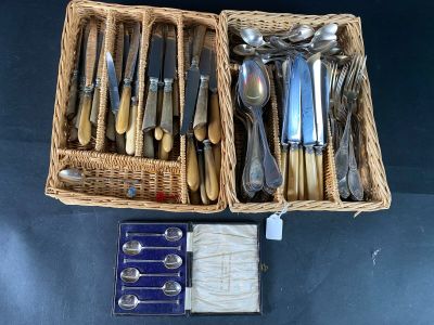 a lot of silverware in a basket on the table