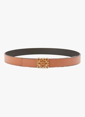 une ceinture marron avec une boucle dorée sur fond blanc