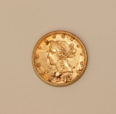 a close up of a gold coin with a woman ' s head on it