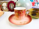 a cup and saucer sitting on a table next to other dishes