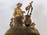 a bronze statue of a man sitting on top of a clock