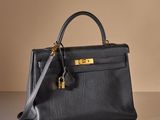 a black leather handbag sitting on top of a table
