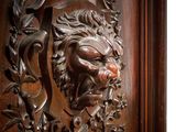 an image of a wooden door with a lion head carved into it