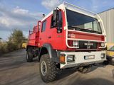a large red truck parked in front of a building