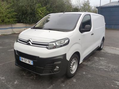 une camionnette Citroën garée sur un parking devant un immeuble