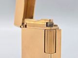 l'image d'un briquet doré posé sur une surface blanche