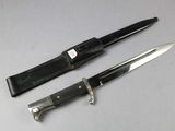 pair of knives with leather sheaths on a white surface