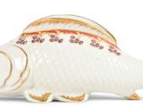 a white fish figurine with a gold decoration on it ' s body