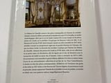 the back cover of a book with a picture of a chandelier in the background