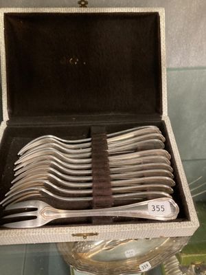 a lot of silver spoons in a box on a table