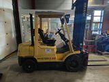 a yellow forklift truck parked in a garage