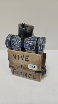 a small figurine of a suitcase with a wine glass in it