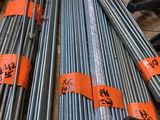 un tas de barres d'acier empilées les unes sur les autres dans un entrepôt
