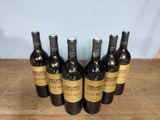 six bottles of wine sitting on top of a wooden table