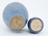 a small blue vase with a brown lid next to a smaller blue vase