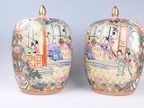 une paire de vases chinois ornés de personnages peints, posés sur une table