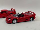 two red toy cars sitting next to each other on a white surface