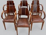 un ensemble de quatre fauteuils en cuir avec accoudoirs en bois