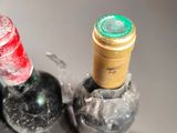 three bottles of wine in a glass holder on the counter