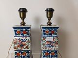 two blue and white vases sitting on a clear shelf