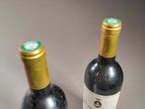 two bottles of wine sitting next to each other on a table